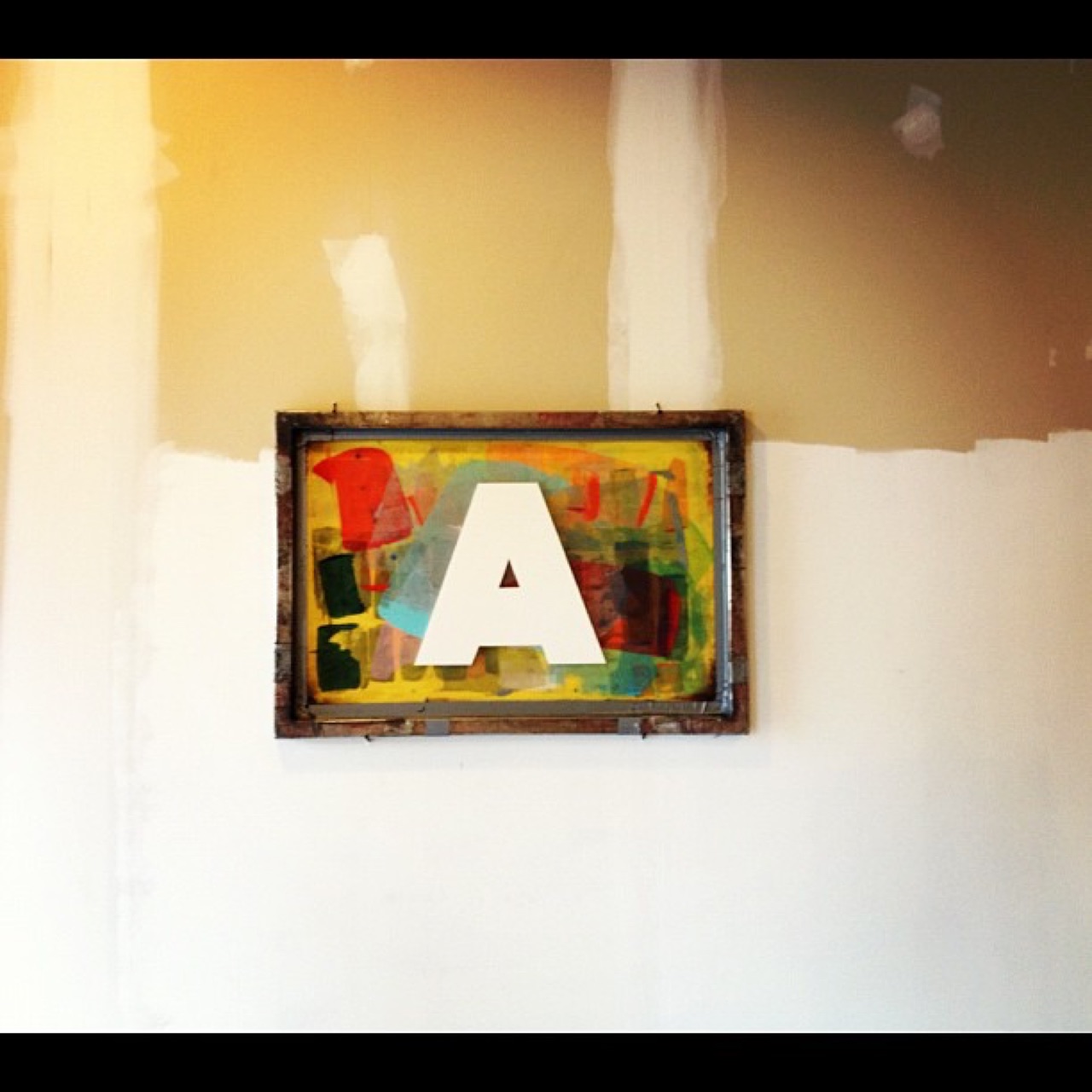 Letter A silkscreen on a patched wall