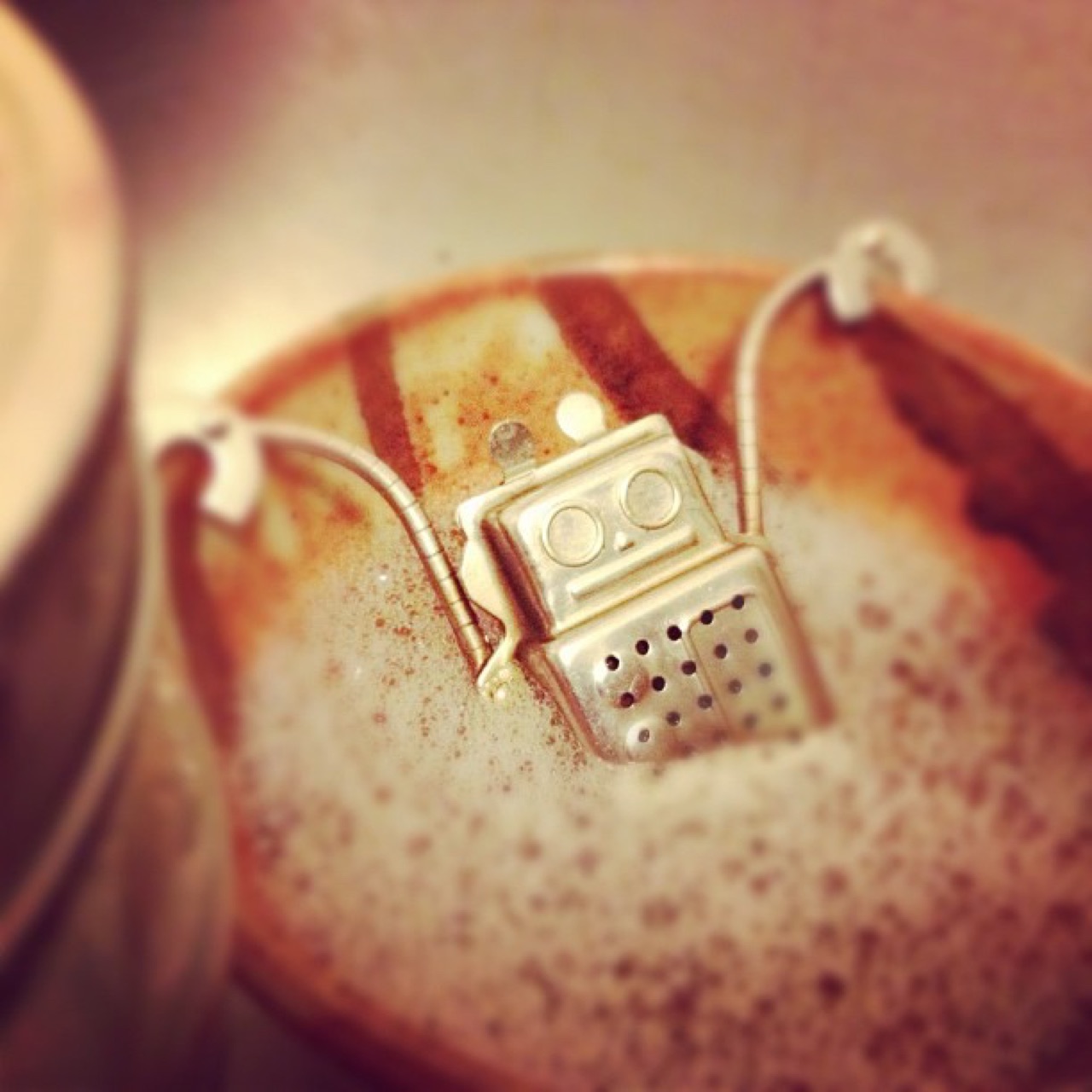 Robot tea infuser in a foamy mug