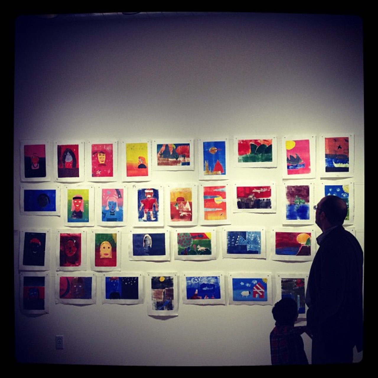 Taking in a wall of bright paintings