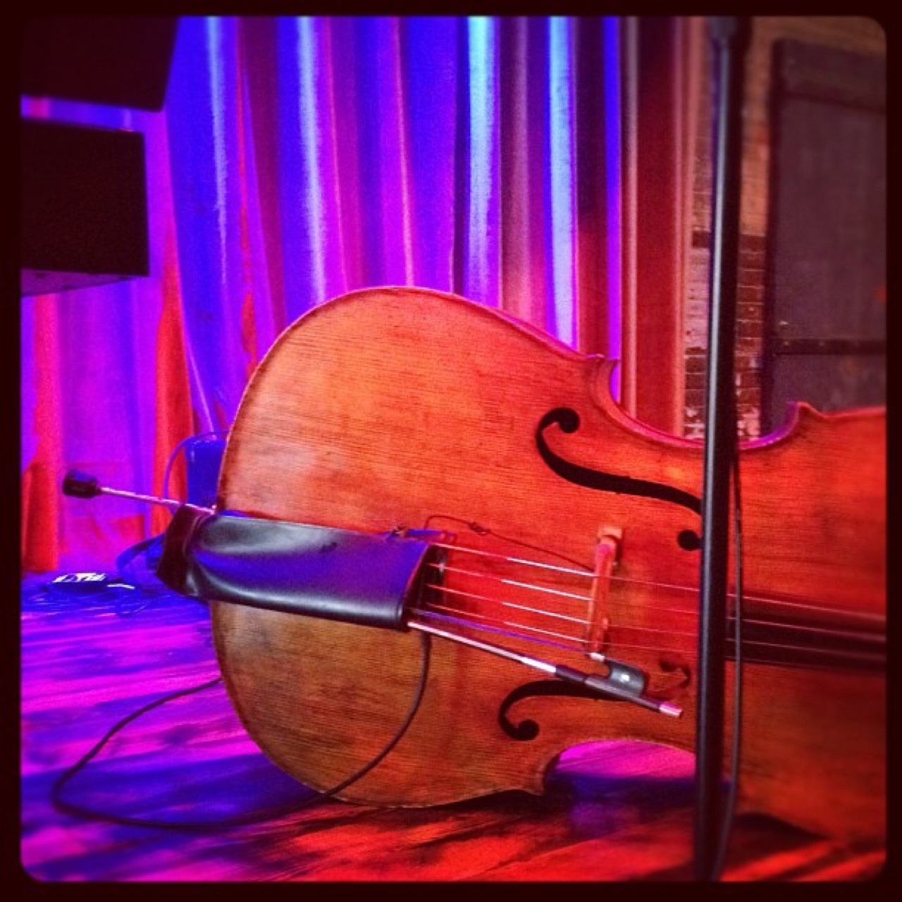 Upright bass resting on a lit stage