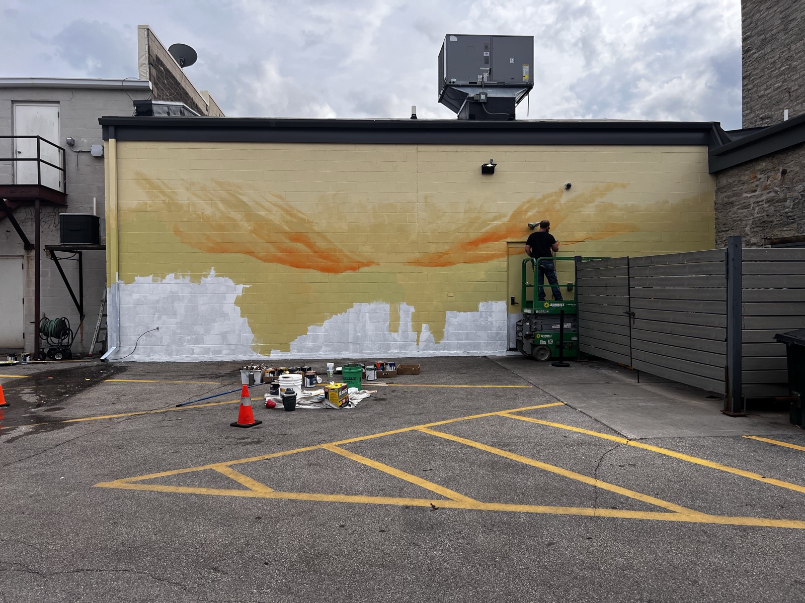 The wall with a warm cream-and-orange sky underpainting brushed across the upper two thirds