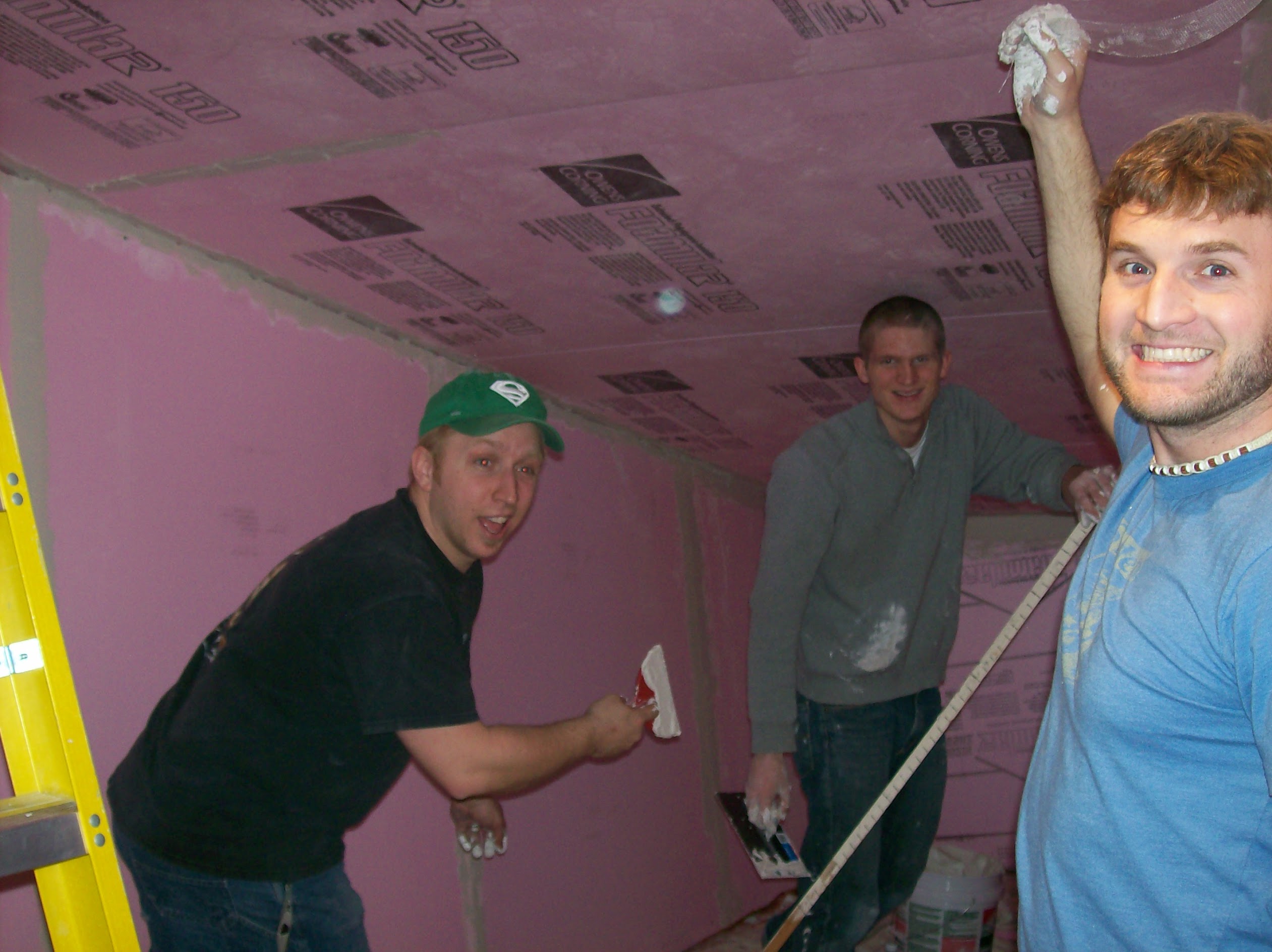 Chris, Joey, and me plastering the attic, mid-build. This photograph is part of the piece even though it isn't.