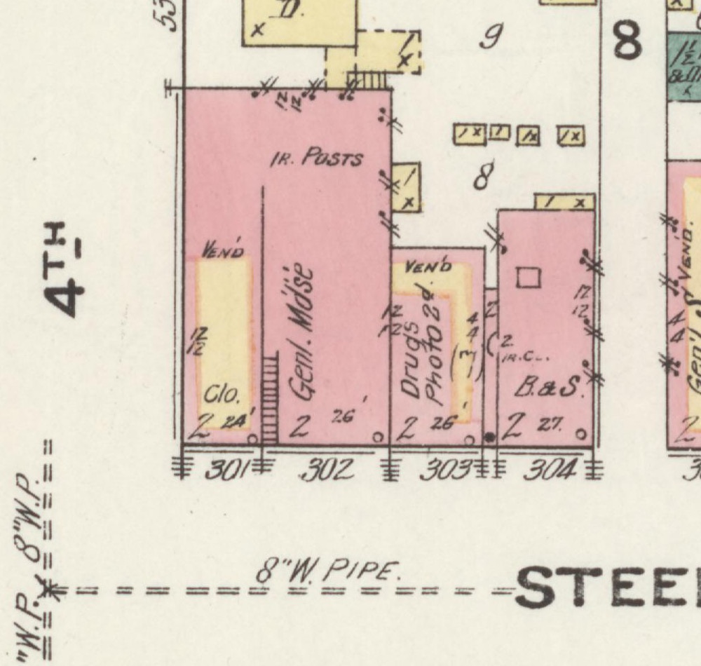 Detail of the November 1909 Sanborn fire-insurance map of Algoma: the north side of Steele Street just east of 4th Street, with the Wilbur Building's brick footprint annotated 'Drugs' on the first floor and 'Photo 2d' — the photograph gallery on the second.